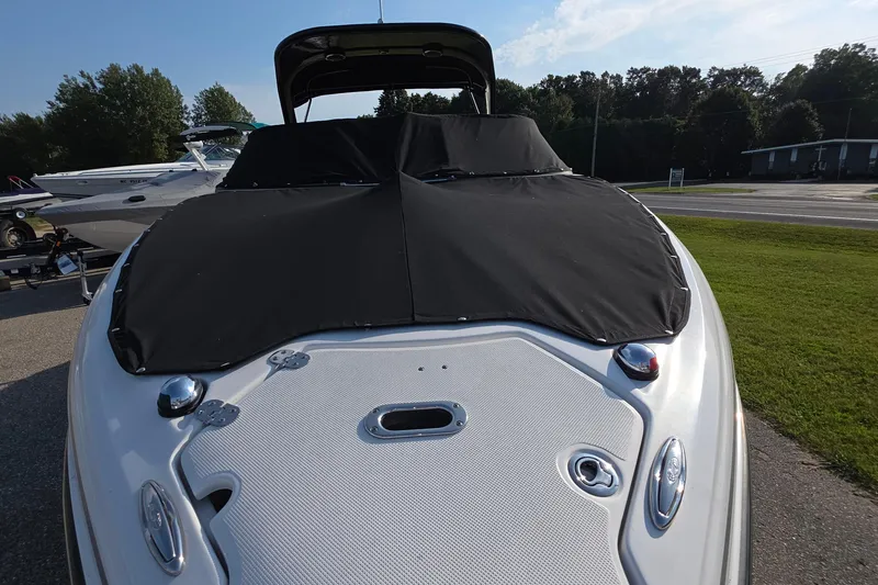 Slide: The Image of 2013 Rinker 276 Captiva Bowrider with black cover, parked outdoors. - 17