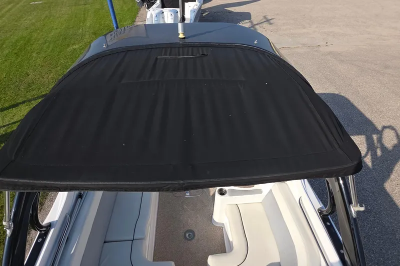 Slide: The Image of 2013 Rinker 276 Captiva Bowrider with black bimini top and white seating. - 18