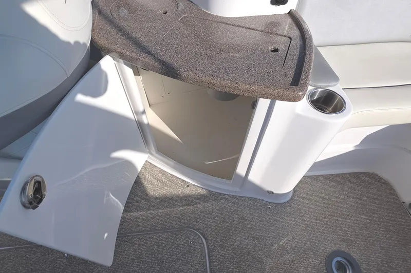 Slide: The Image of 2013 Rinker 276 Captiva Bowrider interior storage compartment with open door and cup holder. - 23