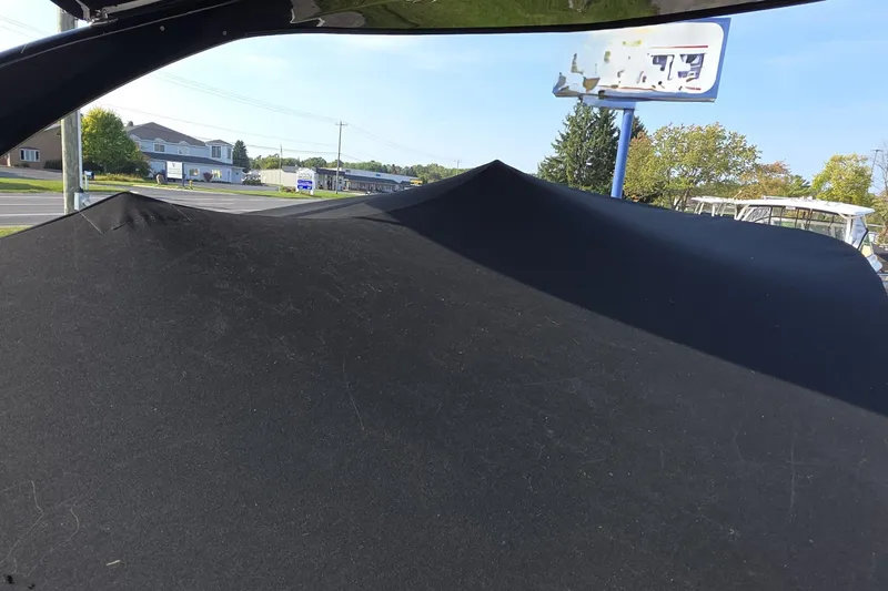 Slide: The Image of 2013 Rinker 276 Captiva Bowrider covered, parked near a road with buildings. - 37