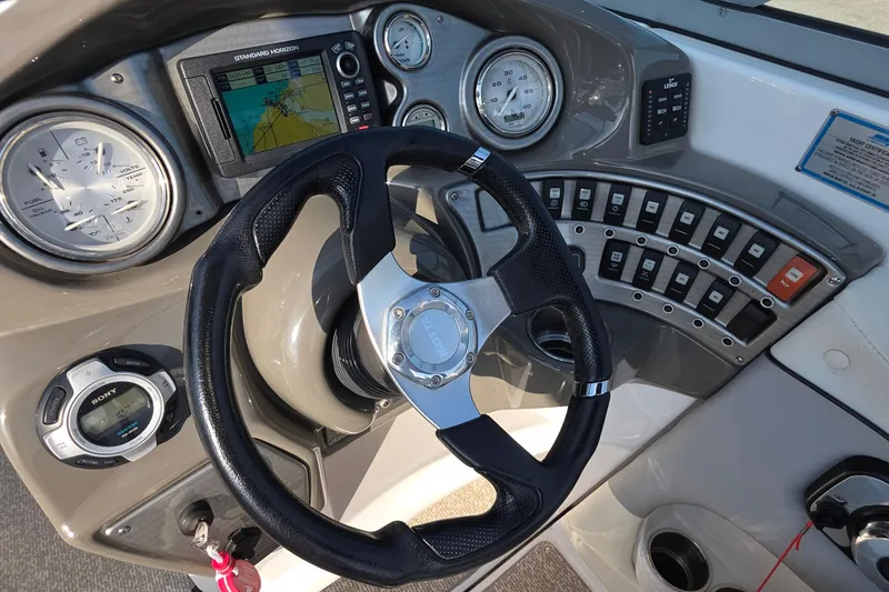 Slide: The Image of 2013 Rinker 276 Captiva Bowrider dashboard with steering wheel and navigation controls. - 8