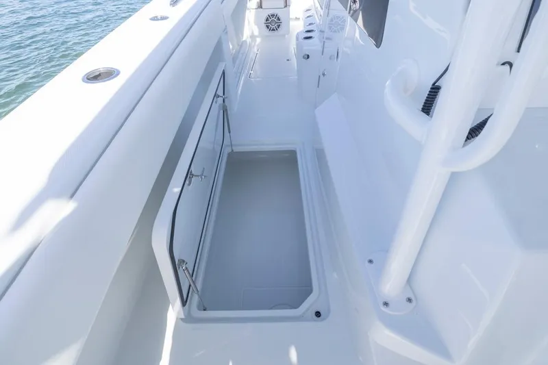 Slide: The Image of 2026 Invincible 46 Catamaran deck with open storage compartment, sleek white design. - 32
