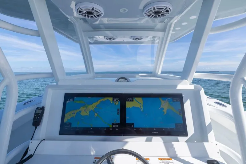 Slide: The Image of Helm of 2026 Invincible 46 Catamaran with dual navigation screens on open water. - 33