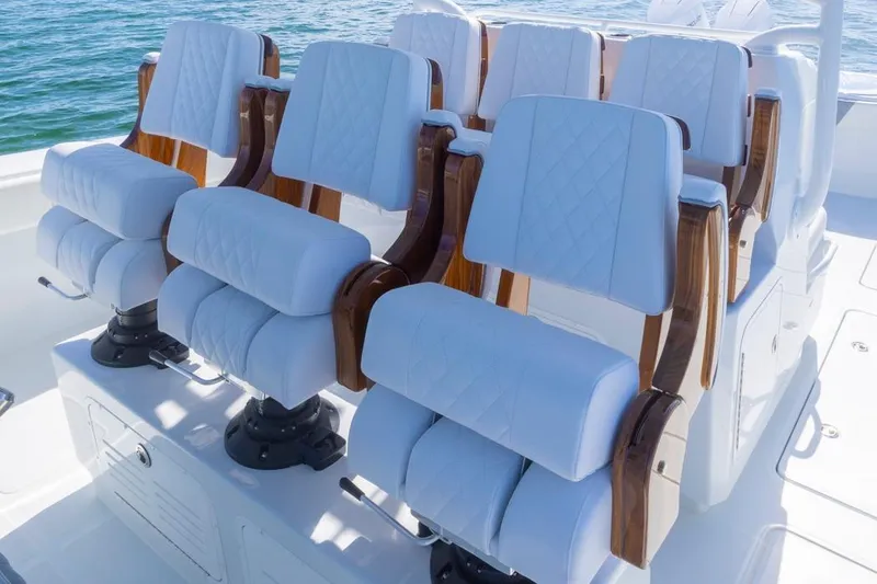 Slide: The Image of Luxurious seating on 2026 Invincible 46 Catamaran, featuring white cushioned chairs with wooden accents. - 38