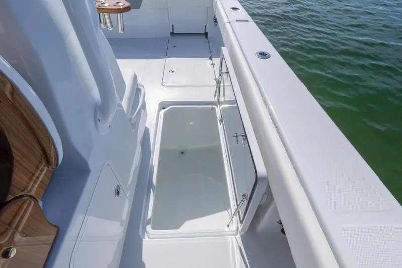 Slide: The Image of 2026 Invincible 46 Catamaran deck with storage compartment, sleek design, and ocean view. - 46