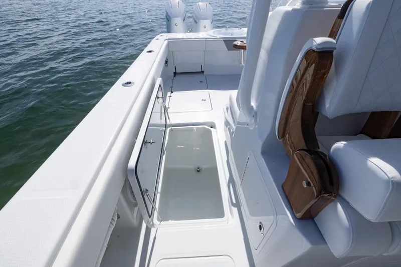Slide: The Image of 2026 Invincible 46 Catamaran deck with open storage compartment, luxurious seating, and ocean view. - 47