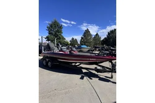 Slide: The Image of 2017 Skeeter FX21 bass boat on trailer, parked outdoors under clear blue sky. - 4