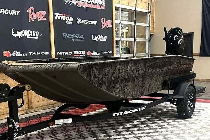 Slide: The Image of 2026 Tracker Grizzly 1650 T Prairie Wings Edition boat on display in showroom. - 3