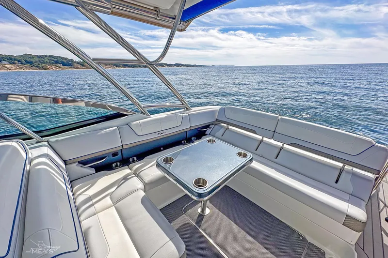 Slide: The Image of 2018 Formula 350 FX Crossover Bowrider interior with ocean view, featuring sleek seating and table. - 12