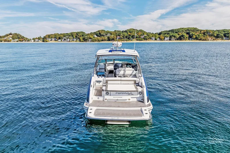 Slide: The Image of 2018 Formula 350 FX Crossover Bowrider on serene blue water, distant shoreline view. - 7