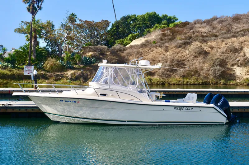 The Image of 1999 Pursuit 2870 Walkaround boat docked in a scenic marina setting. - 0