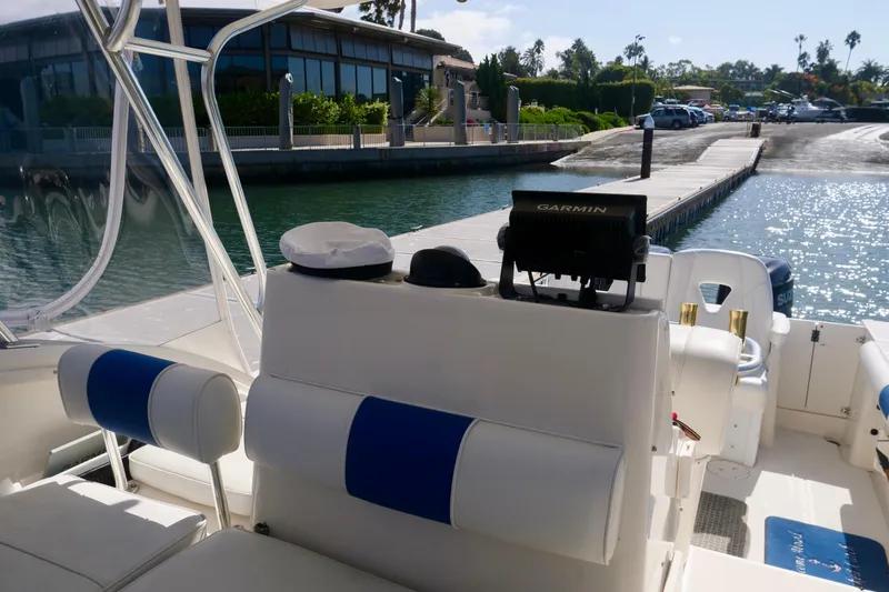 Slide: The Image of 1999 Pursuit 2870 Walkaround boat interior with Garmin equipment, docked near waterfront buildings. - 17