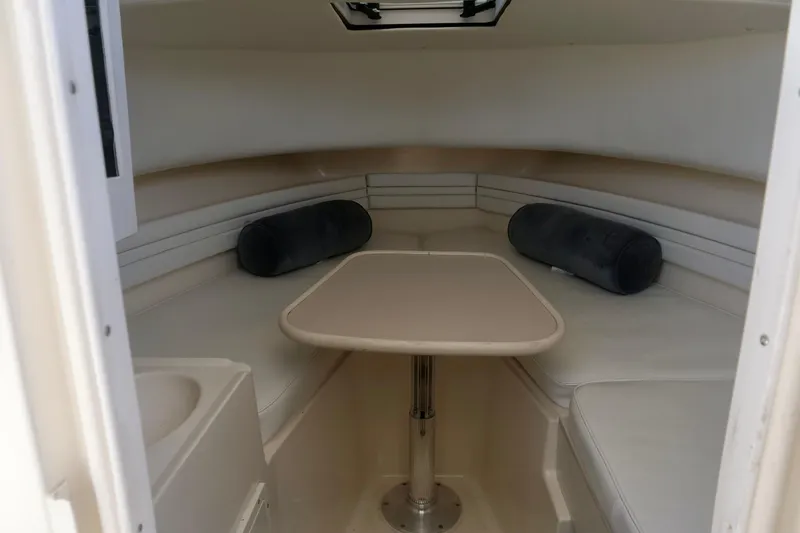 Slide: The Image of 1999 Pursuit 2870 Walkaround cabin interior with table and seating. - 20