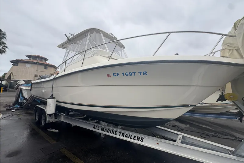 Slide: The Image of 1999 Pursuit 2870 Walkaround boat on trailer, parked outdoors. - 22