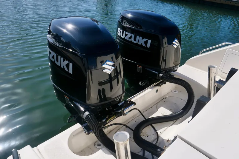 Slide: The Image of Twin Suzuki outboard motors on a 1999 Pursuit 2870 Walkaround boat. - 24