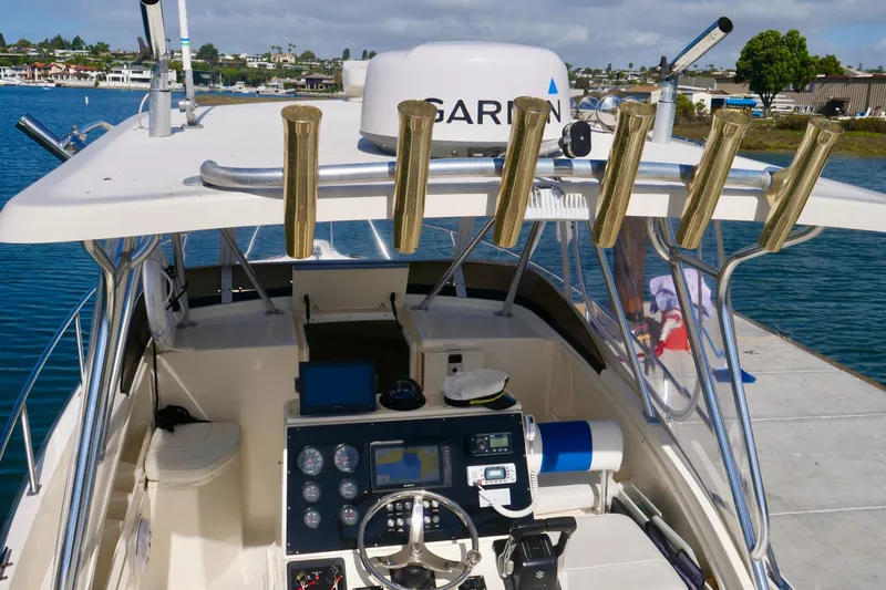 Slide: The Image of 1999 Pursuit 2870 Walkaround boat cockpit with navigation equipment and rod holders. - 5