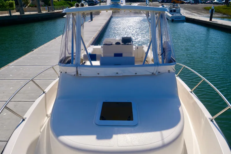 Slide: The Image of 1999 Pursuit 2870 Walkaround boat docked at marina, sunny day, clear water. - 6