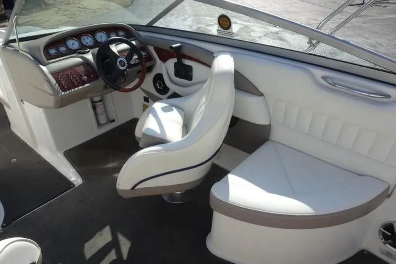 Slide: The Image of Interior of a 2003 Cobalt 24SD boat with white seating and dashboard controls. - 11