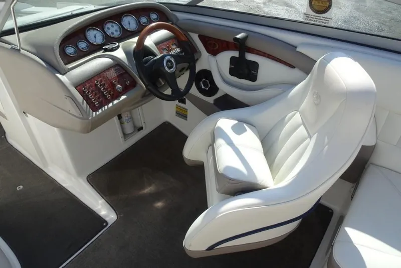 Slide: The Image of Interior of a 2003 Cobalt 24SD boat with white captain's chair and dashboard. - 12