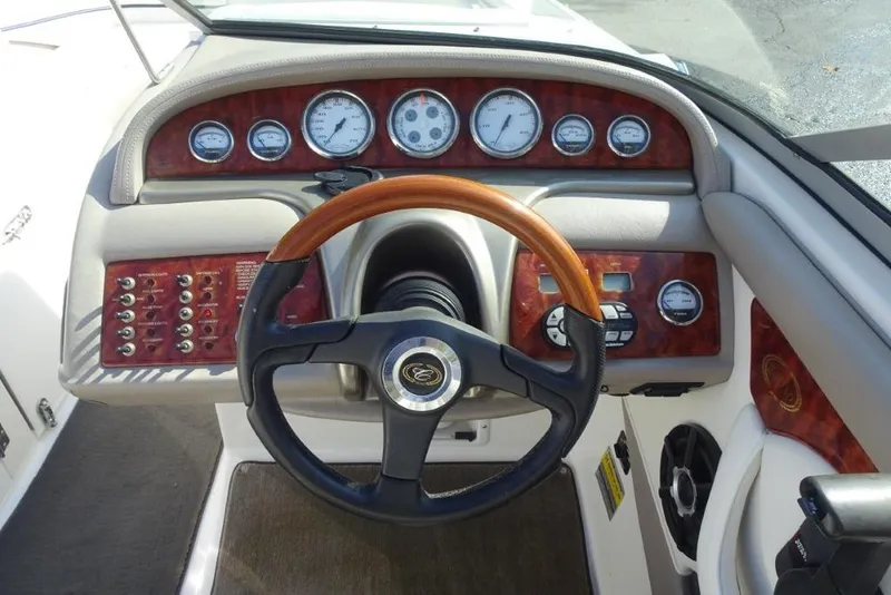Slide: The Image of Steering console of a 2003 Cobalt 24SD boat with wood accents and gauges. - 13