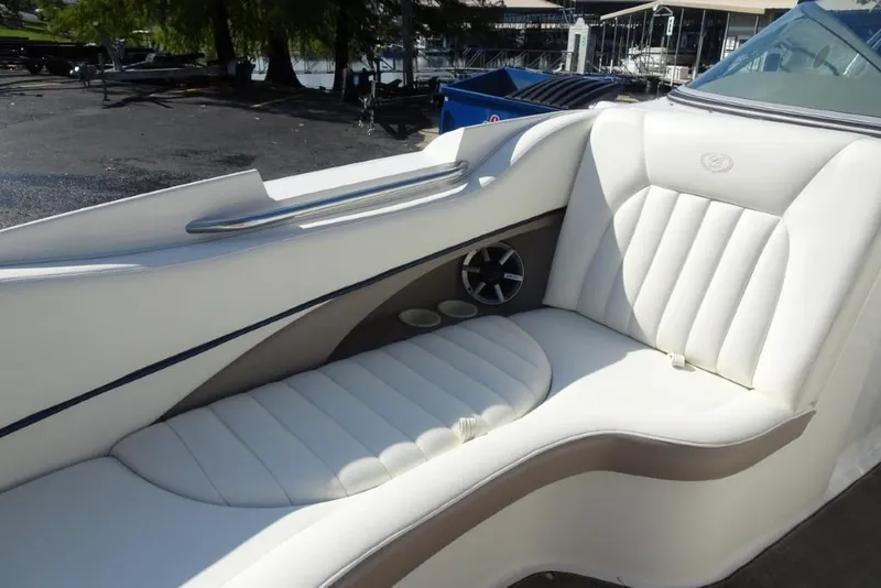 Slide: The Image of Luxurious seating on a 2003 Cobalt 24SD boat, featuring white upholstery and cup holders. - 18