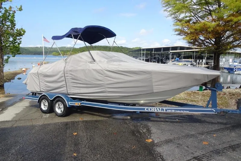 Slide: The Image of Covered 2003 Cobalt 24SD boat on trailer by a lakeside dock. - 22