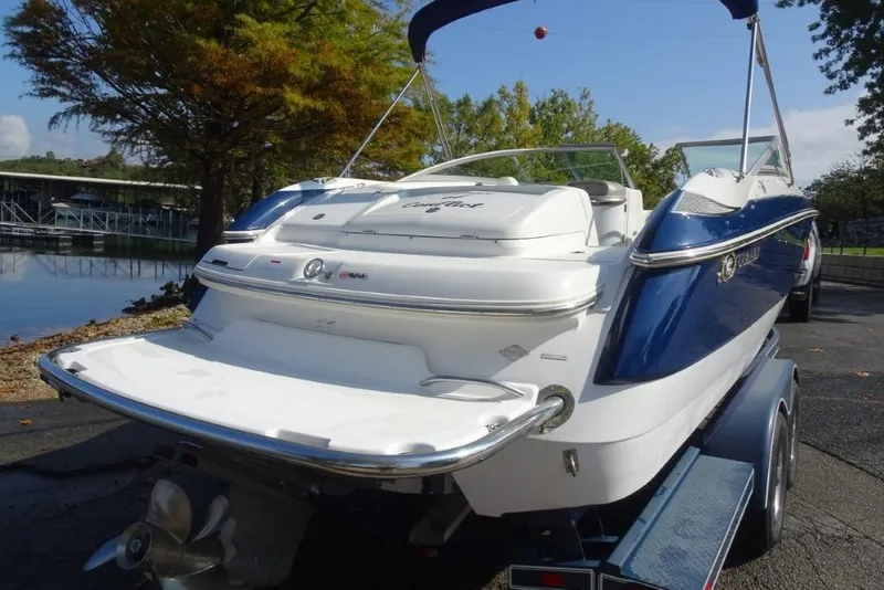 Slide: The Image of 2003 Cobalt 24SD boat on trailer, blue and white, near a lake. - 5