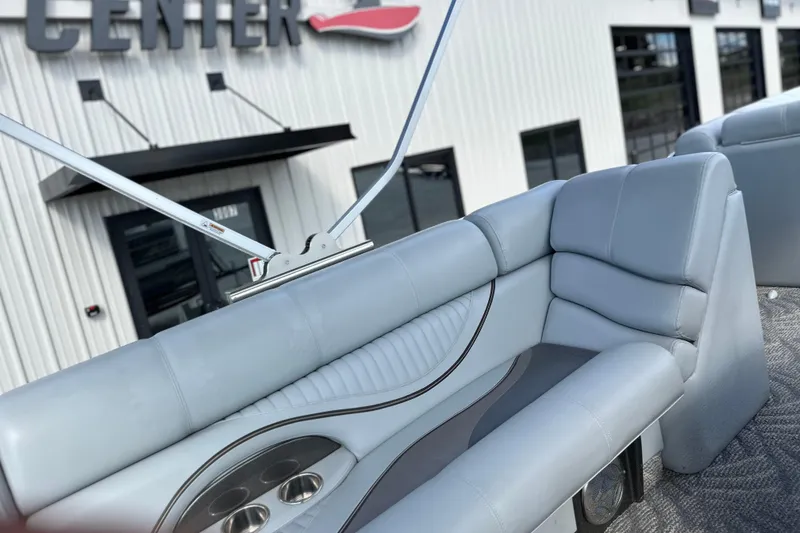 Slide: The Image of 2011 South Bay 925 CR boat interior with gray seating and cup holders, near a building. - 11