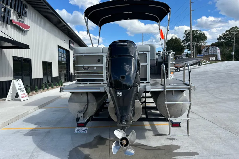 Slide: The Image of 2011 South Bay 925 CR pontoon boat with outboard motor at a dealership. - 2