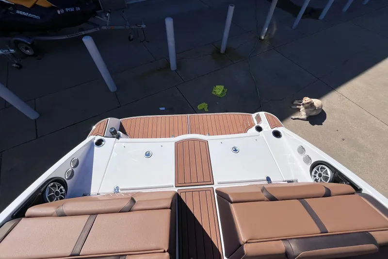 Slide: The Image of 2026 Yamaha Boat 222SE with brown seating, docked, and a dog resting nearby. - 4