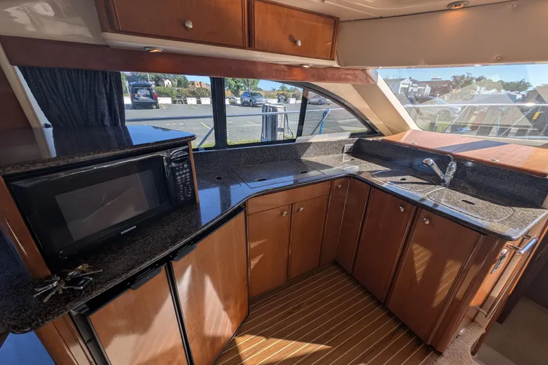 Slide: The Image of Luxurious kitchen interior of 2006 Meridian 411 Sedan yacht with granite countertops and wood cabinetry. - 14