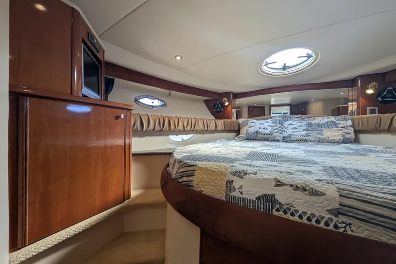 Slide: The Image of Luxurious 2006 Meridian 411 Sedan yacht bedroom with cozy bedding and elegant wood cabinetry. - 22