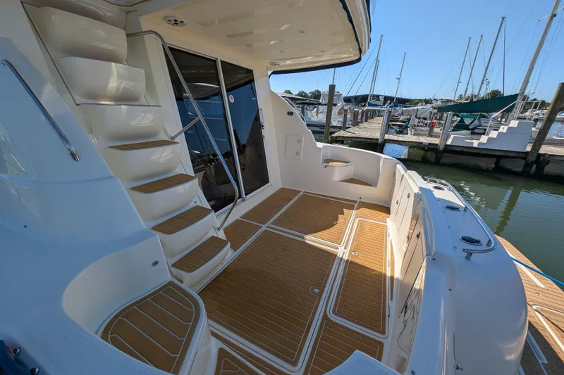 Slide: The Image of 2006 Meridian 411 Sedan yacht deck with wooden flooring and docked marina view. - 5
