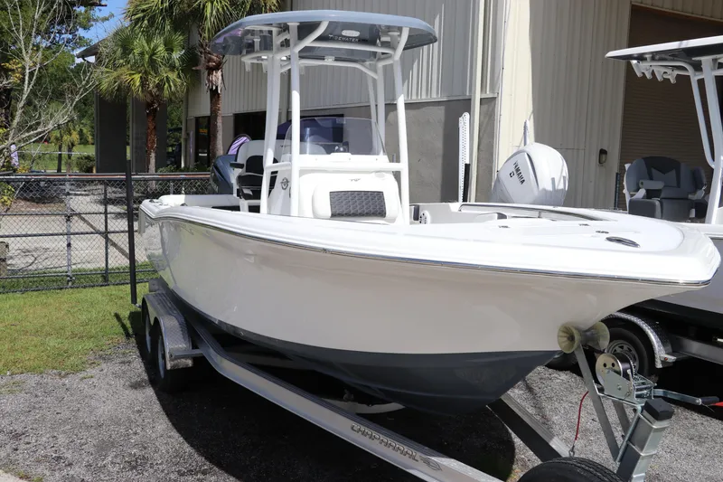 Slide: The Image of 2024 Tidewater 220 LXF boat on trailer, parked outdoors near a building. - 0