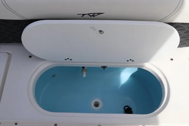 Slide: The Image of 2024 Tidewater 220 LXF boat livewell with open lid, showcasing interior design. - 10