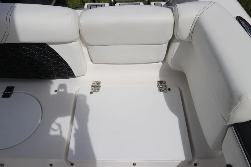 Slide: The Image of 2024 Tidewater 220 LXF boat interior with white cushioned seating and storage compartment. - 11