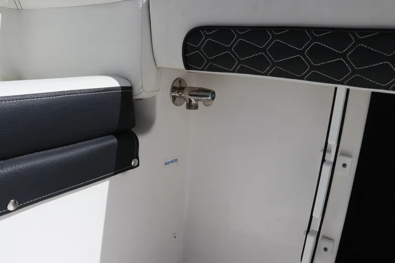 Slide: The Image of Interior detail of 2024 Tidewater 220 LXF boat, featuring sleek upholstery and raw water outlet. - 13