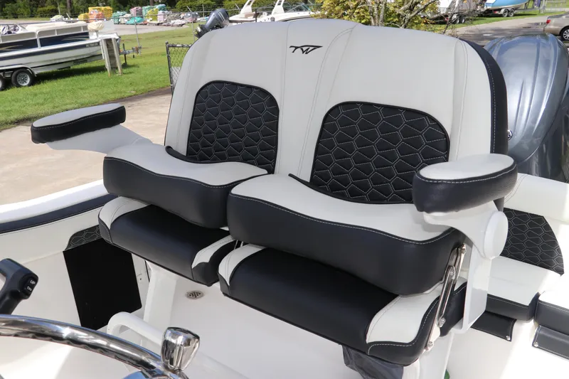 Slide: The Image of 2024 Tidewater 220 LXF boat seats with black and white upholstery and armrests. - 19