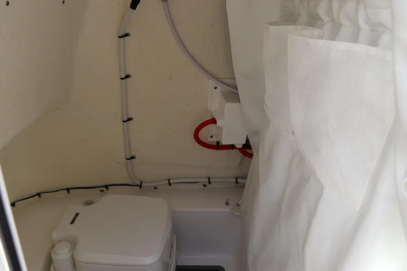 Slide: The Image of 2024 Tidewater 220 LXF boat interior with compact toilet and storage. - 35