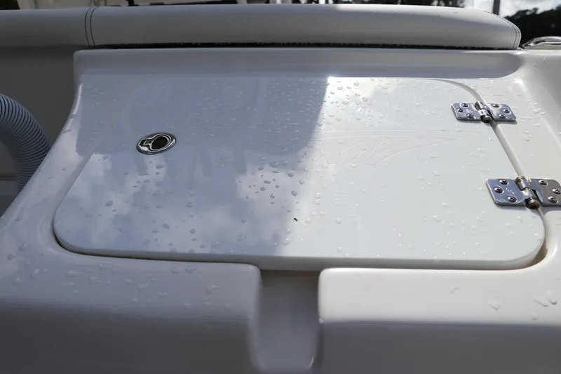 Slide: The Image of 2024 Tidewater 220 LXF boat hatch with water droplets and stainless steel hinges. - 53