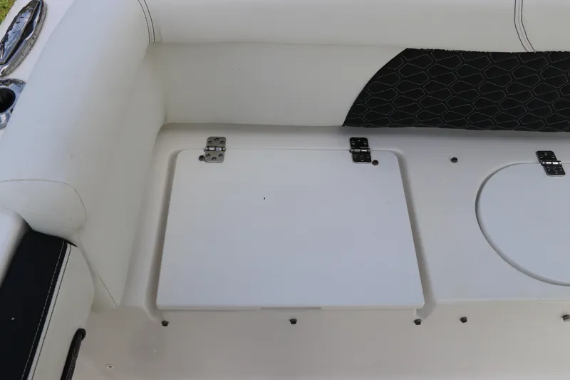 Slide: The Image of 2024 Tidewater 220 LXF boat interior with white cushioned seating and storage compartments. - 7