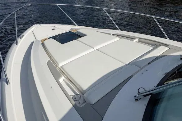 Slide: The Image of 2022 Tiara Sport 43 LE boat with spacious sunbathing deck on calm water. - 14