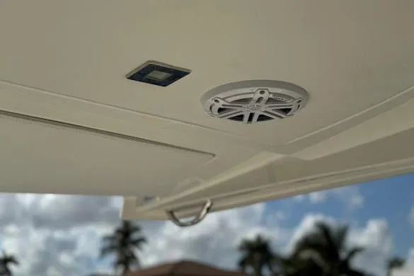 Slide: The Image of 2022 Tiara Sport 43 LE boat ceiling with speaker and light, palm trees in background. - 26