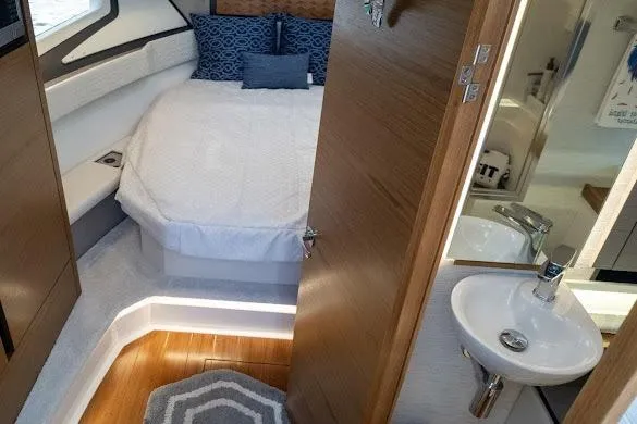 Slide: The Image of 2022 Tiara Sport 43 LE cabin interior with bed, sink, and modern decor. - 31
