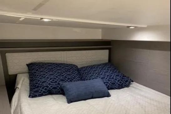 Slide: The Image of 2022 Tiara Sport 43 LE cabin with cozy bed and blue pillows. - 34