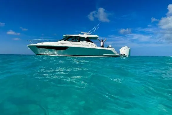 Slide: The Image of 2022 Tiara Sport 43 LE yacht cruising on clear blue ocean waters. - 5