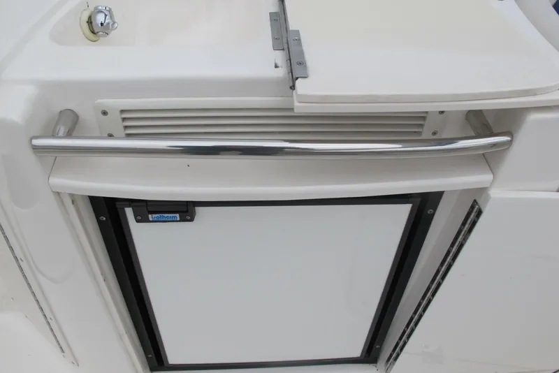 Slide: The Image of 2003 Chaparral 280 SSi boat kitchenette with compact fridge and stainless steel handle. - 12