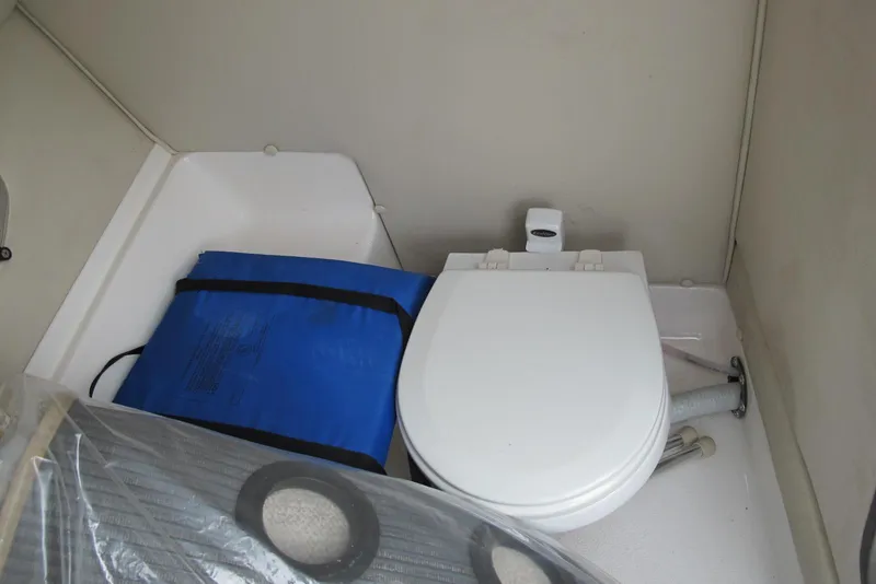 Slide: The Image of 2003 Chaparral 280 SSi boat interior with toilet and blue storage bag. - 13