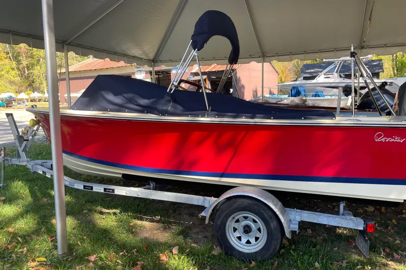Slide: The Image of Red 2020 Rossiter 20 Coastal Cruiser boat on trailer under canopy. - 0