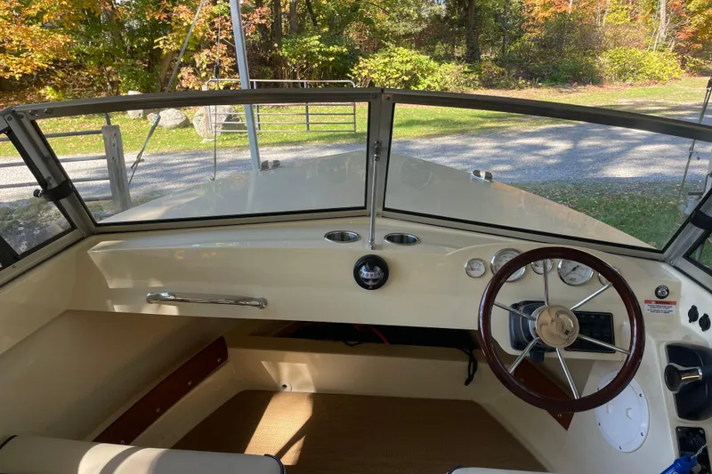 Slide: The Image of 2020 Rossiter 20 Coastal Cruiser interior with steering wheel and dashboard, surrounded by autumn foliage. - 10